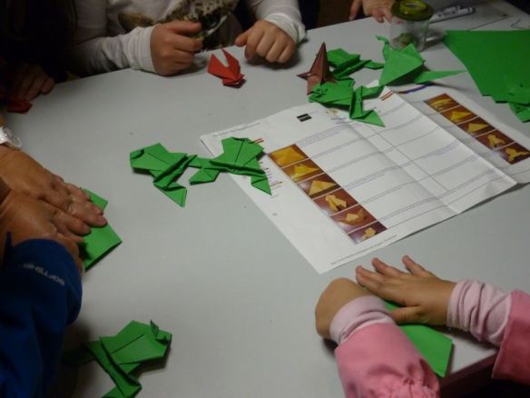 Kinderhände beim Falten der springenden Laubfrösche bei der Langen Nacht der Museen, Info-Stand der Plattform Auwald.